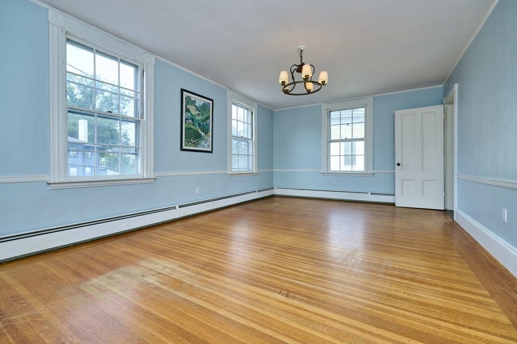 74 Washington Square, Unit 2 Salem, MA 01970 - Photo 9 of 31 an empty room with wooden floor and windows