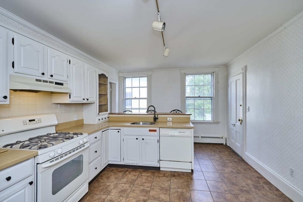 74 Washington Square, Unit 2 Salem, MA 01970 - Photo 10 of 31 a kitchen that has a lot of cabinets in it and wooden floors