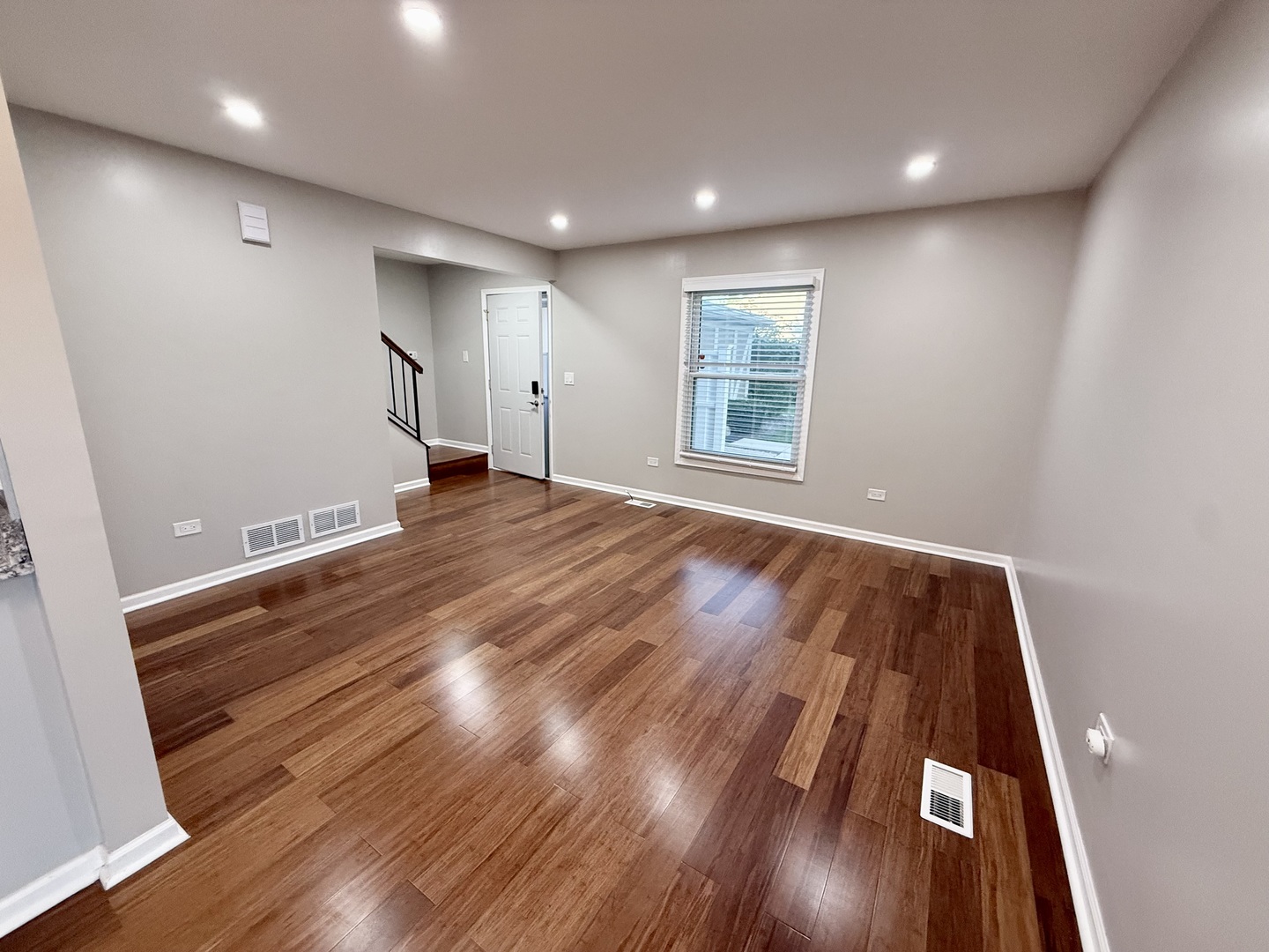 1045 Hampton Harbor, Unit 1045 Schaumburg, IL 60193 - Photo 5 of 18 an empty room with wooden floor and windows