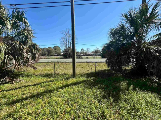 a view of a house with backyard and trees
