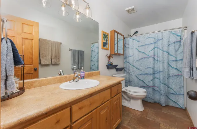 a bathroom with a sink toilet a mirror and shower