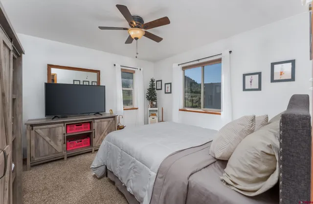 a bedroom with a bed and a flat screen tv on dresser