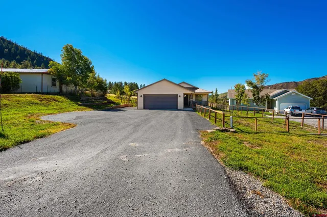 a view of a house with a yard and a garden