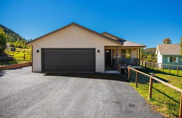 a view of house with backyard and parking
