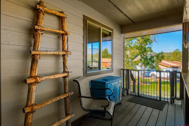 a view of a balcony with chairs and wooden floor