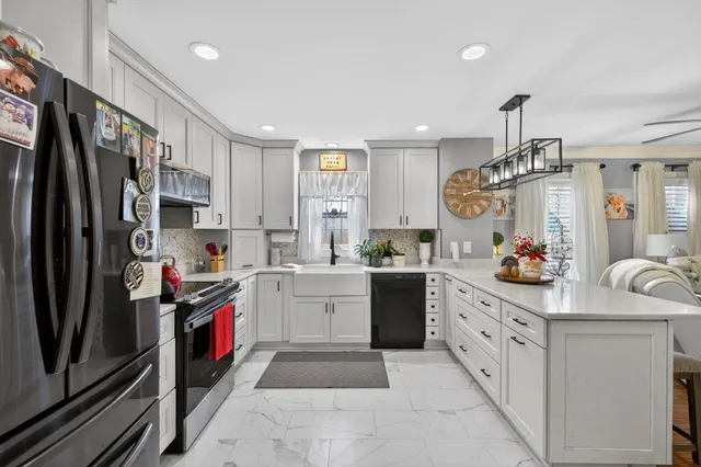 a kitchen with stainless steel appliances white cabinets and a refrigerator
