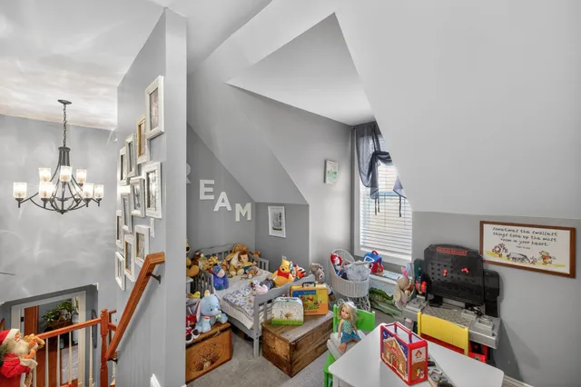 a bedroom with a bed dresser and wooden floor