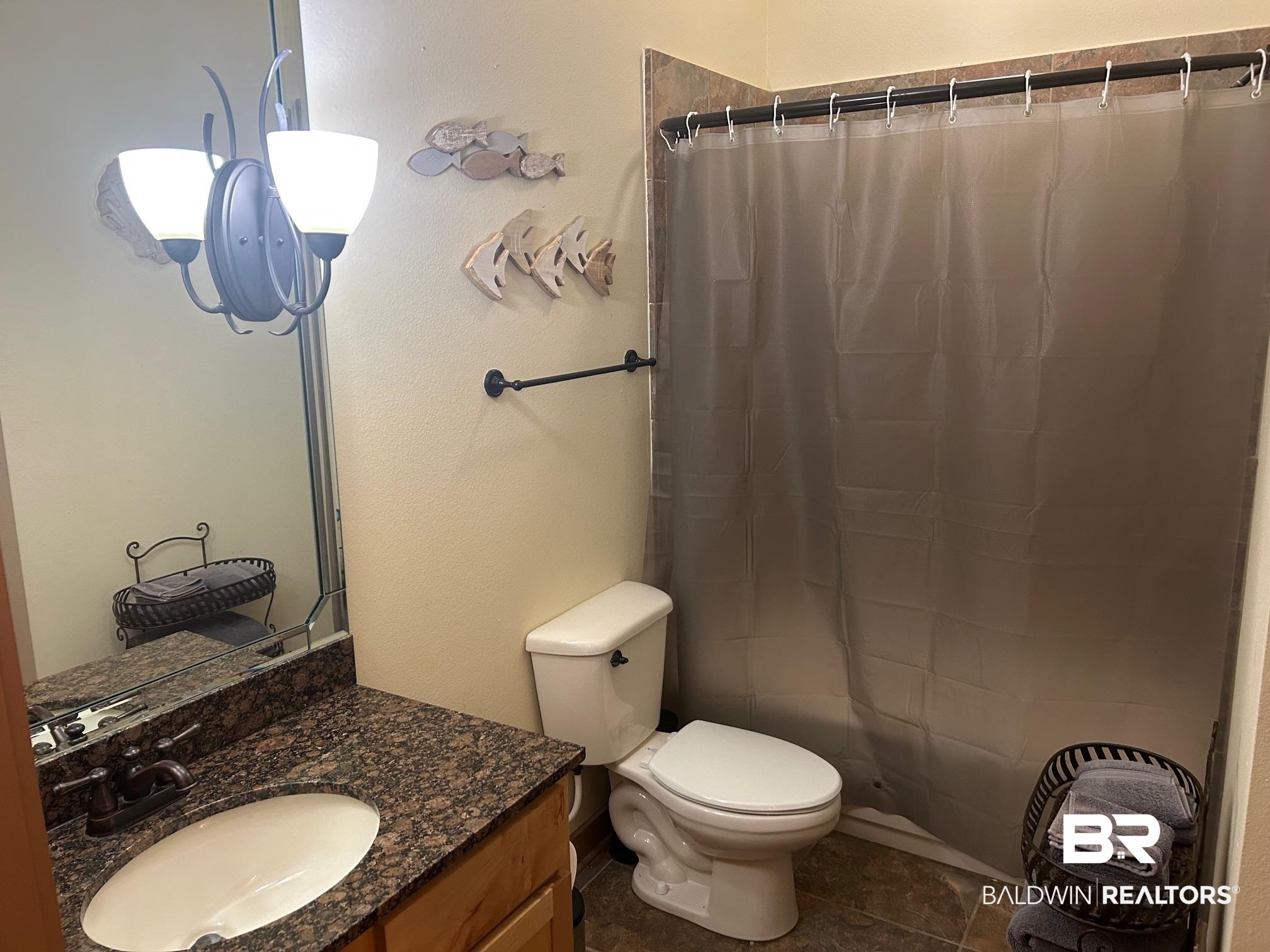 1430 Regency Road, Unit J102 Gulf Shores, AL 36542 - Photo 9 of 11 Bathroom with toilet, walk in shower, tile patterned floors, and vanity