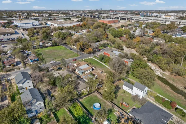 an aerial view of residential houses with outdoor space and trees