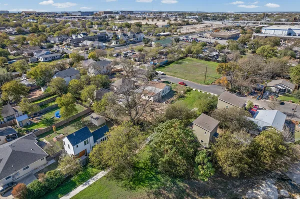 an aerial view of residential houses with outdoor space and trees