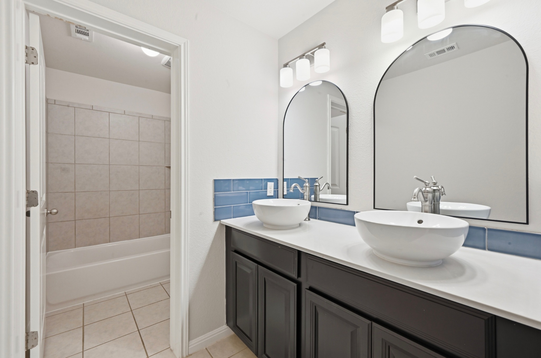 351 Wincliff Drive Buda, TX 78610 - Photo 31 of 40 Dual vessel sinks and arched mirrors create a sleek, contemporary vanity space.