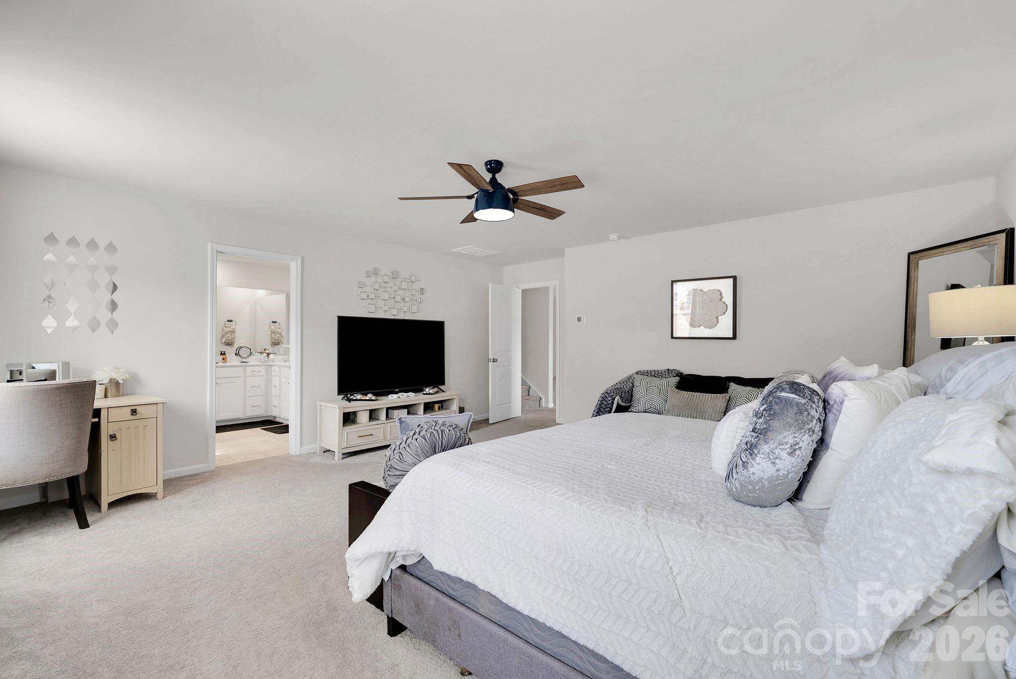 224 Hamptons Cove Road Troutman, NC 28166 - Photo 19 of 47 a bedroom with a bed and a flat screen tv
