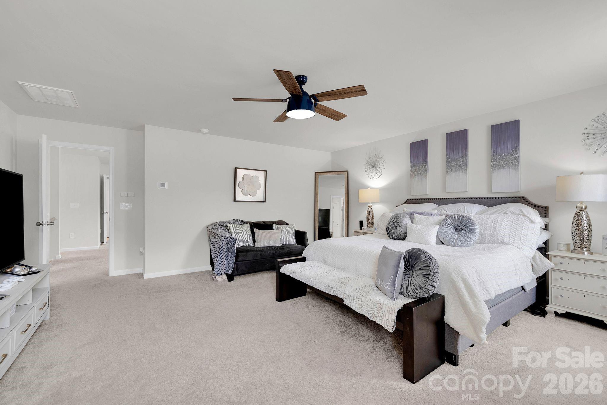 224 Hamptons Cove Road Troutman, NC 28166 - Photo 20 of 47 a spacious bedroom with a bed and a flat screen tv