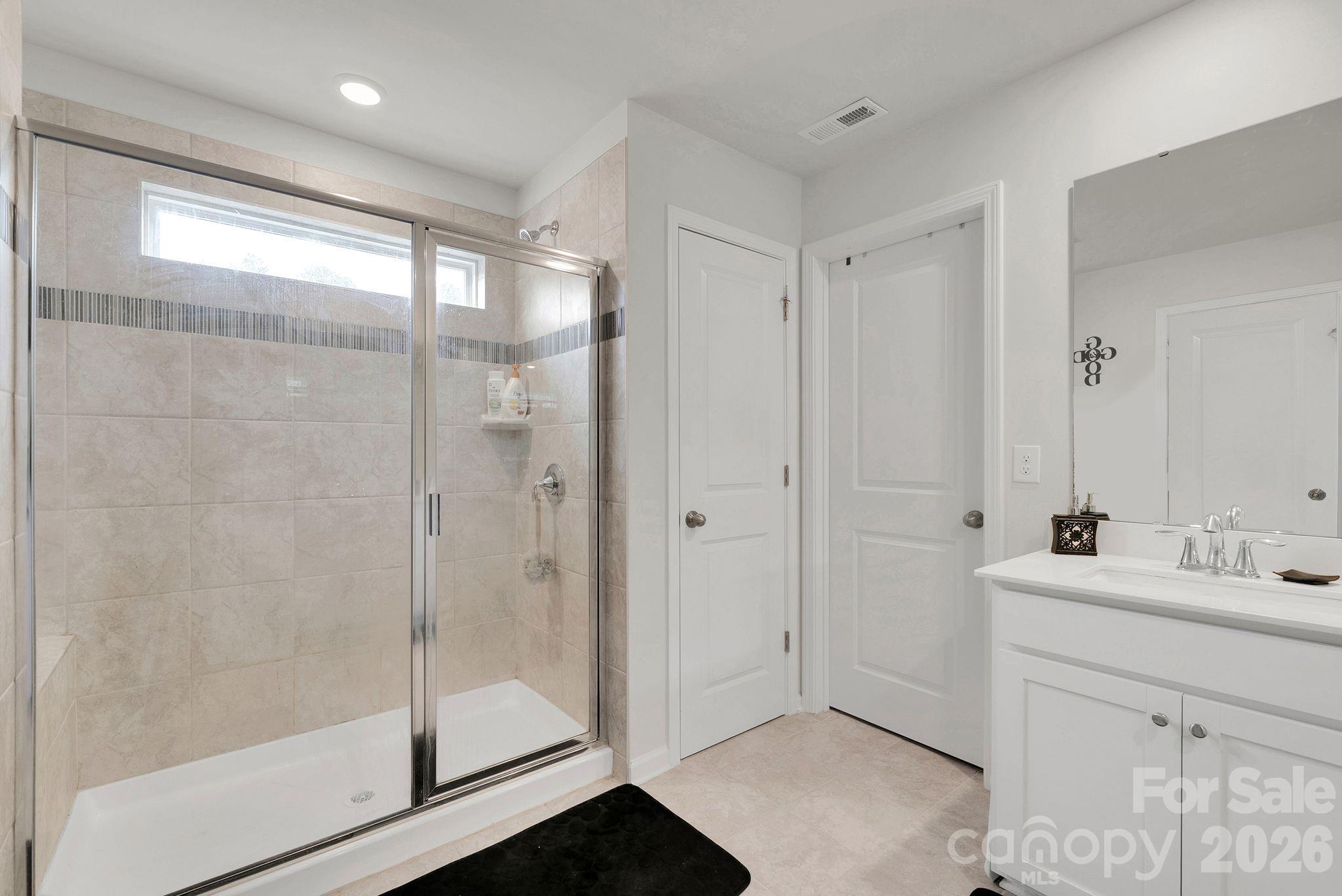 224 Hamptons Cove Road Troutman, NC 28166 - Photo 23 of 47 a bathroom with a shower sink and mirror