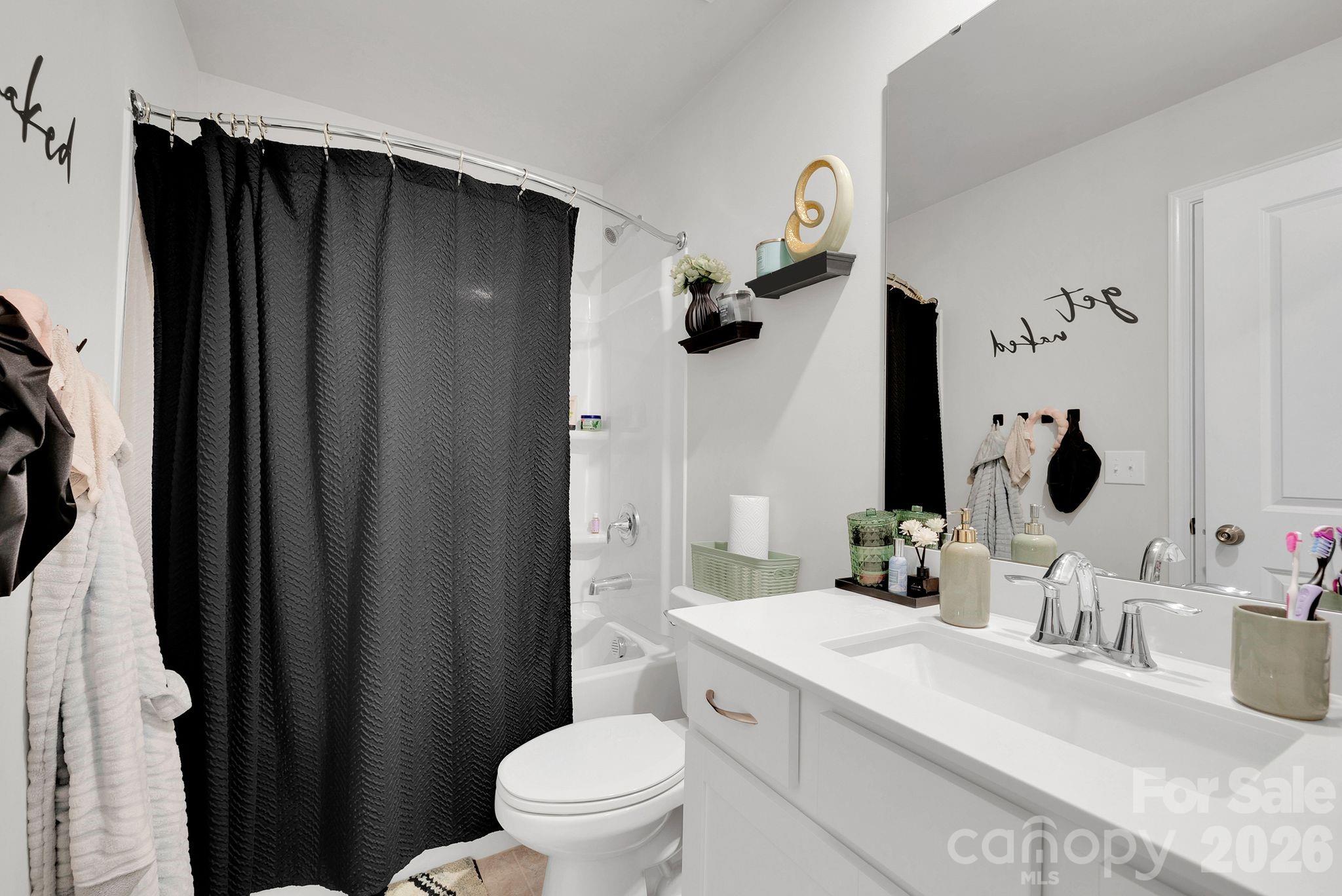 224 Hamptons Cove Road Troutman, NC 28166 - Photo 29 of 47 a bathroom with a sink a toilet a mirror and shower curtain