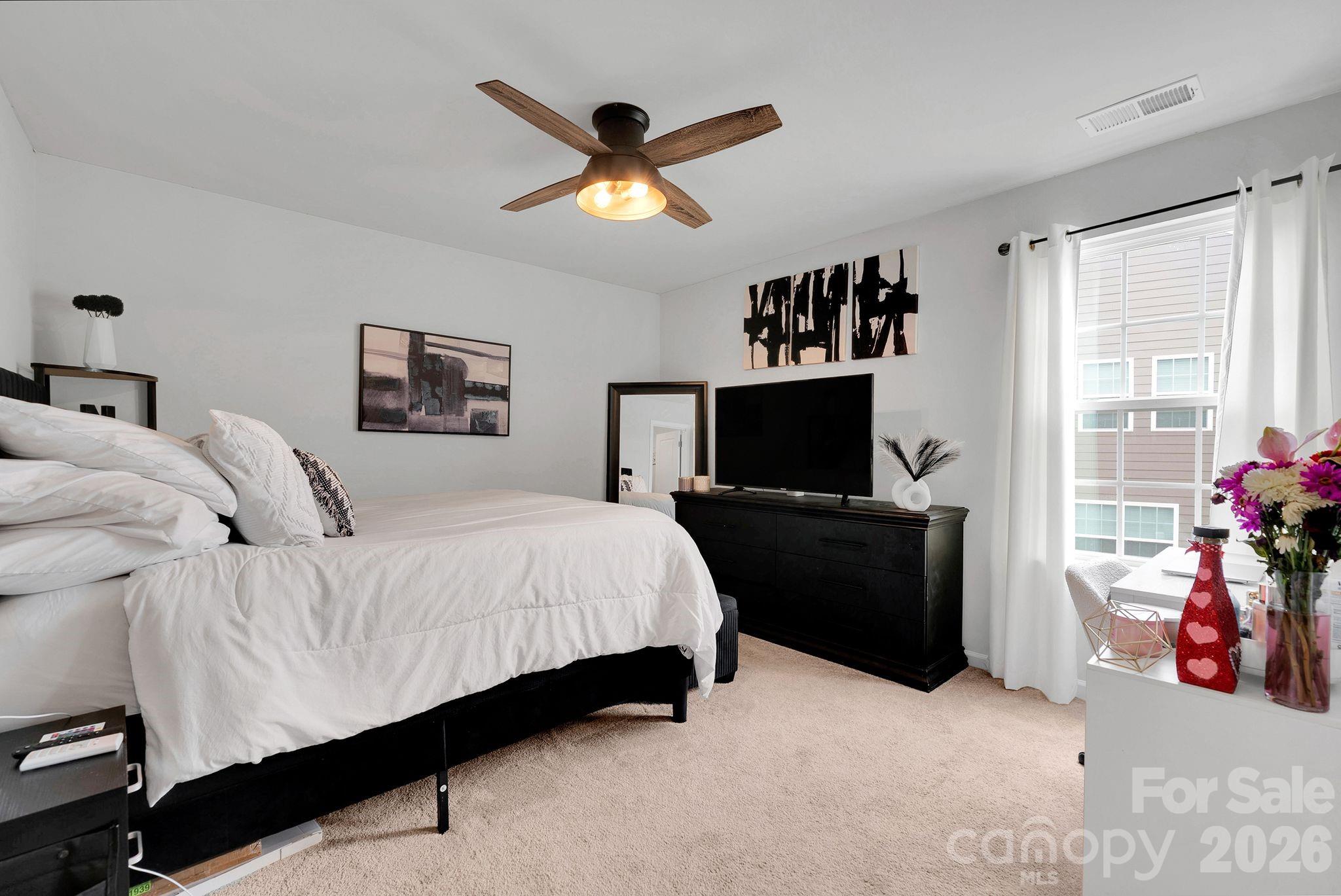 224 Hamptons Cove Road Troutman, NC 28166 - Photo 30 of 47 a bedroom with a bed and a flat screen tv