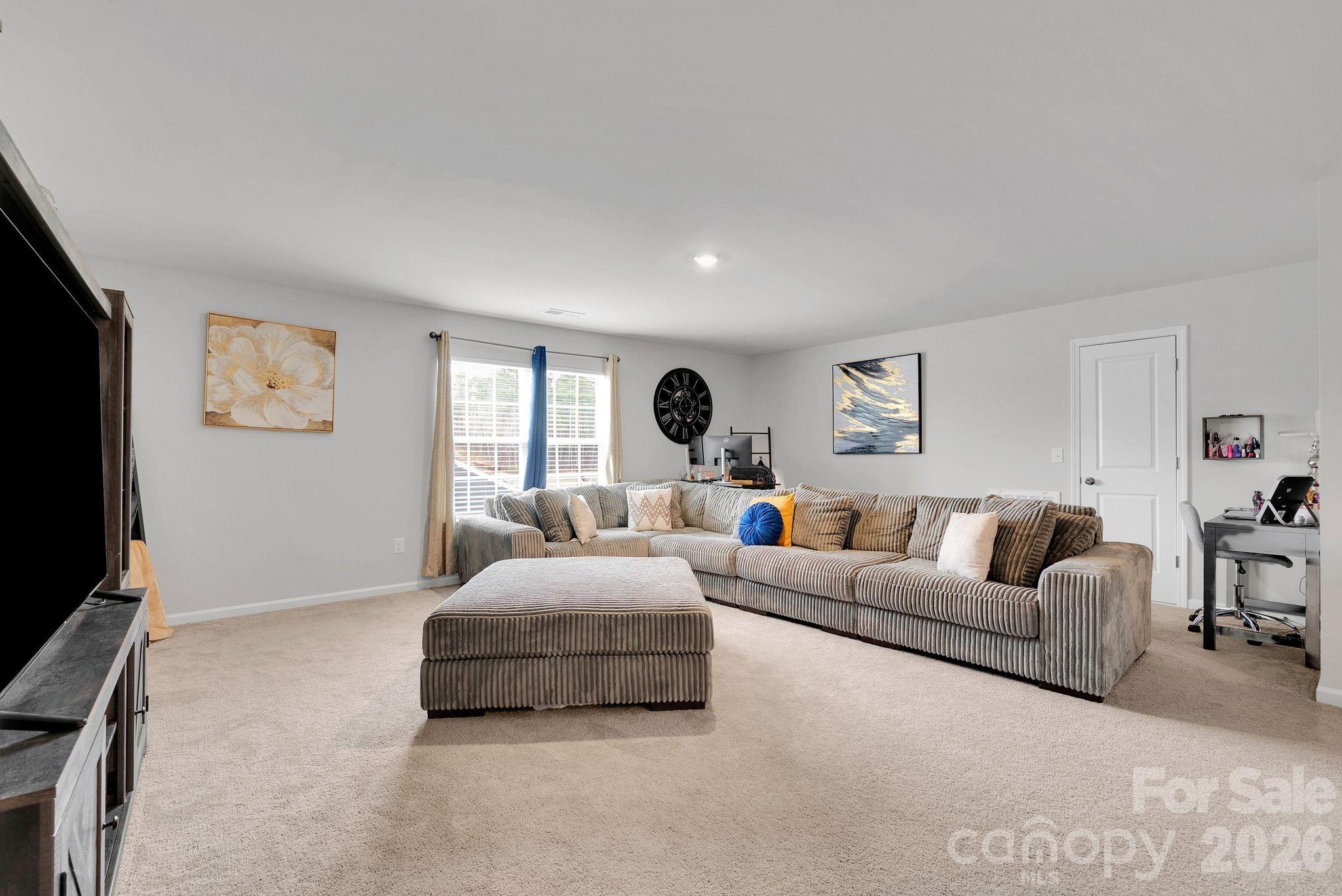 224 Hamptons Cove Road Troutman, NC 28166 - Photo 32 of 47 a living room with furniture and a flat screen tv