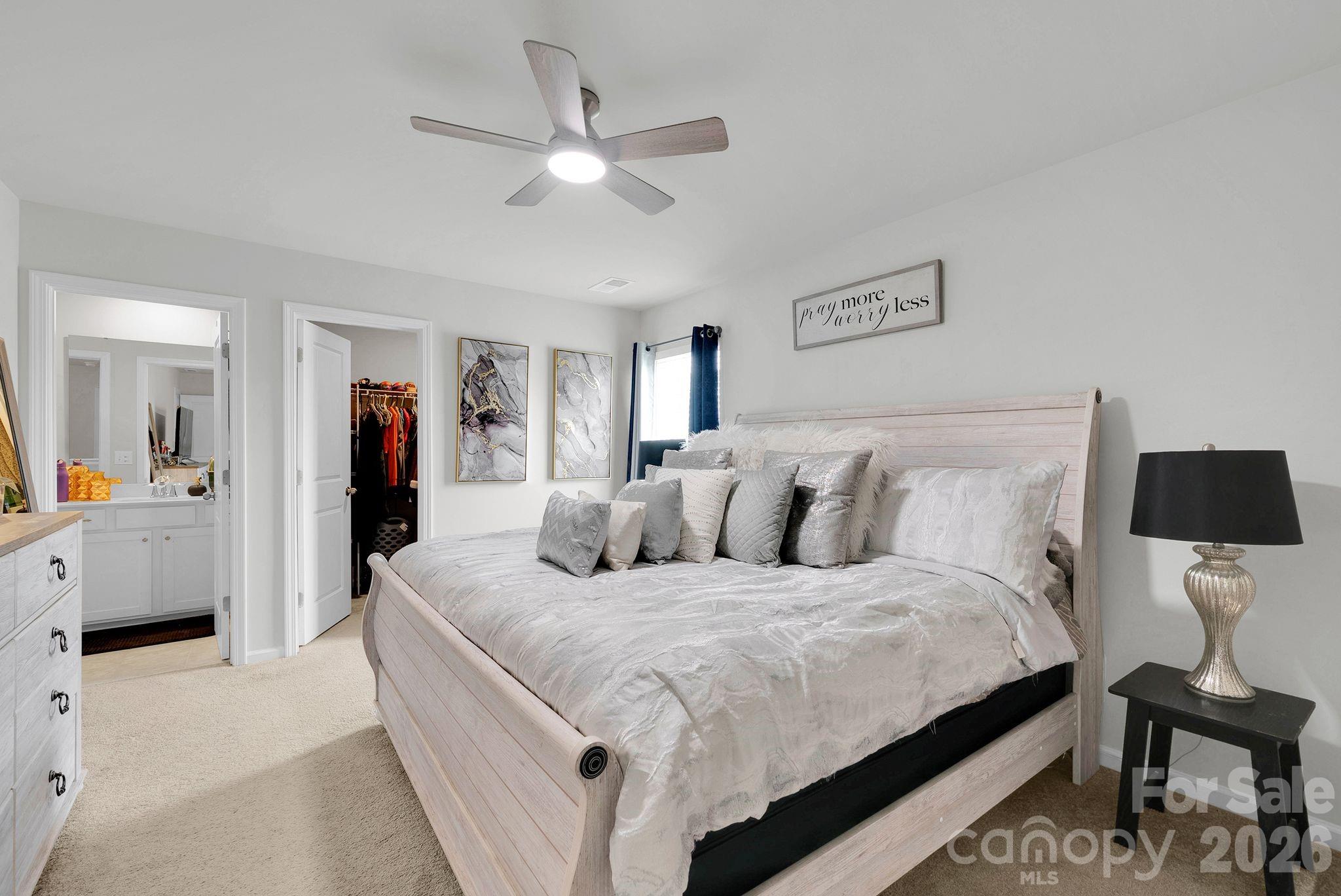 224 Hamptons Cove Road Troutman, NC 28166 - Photo 35 of 47 a large bedroom with a bed and a chandelier