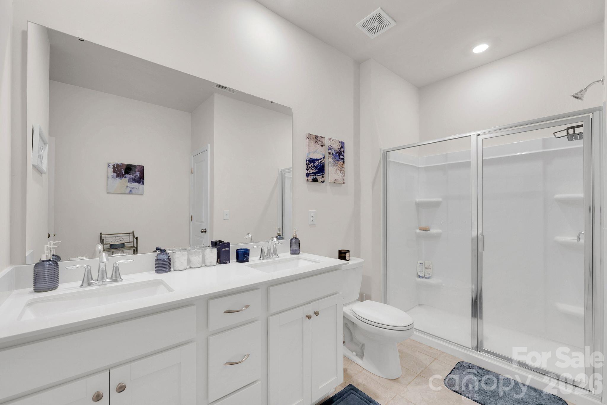 224 Hamptons Cove Road Troutman, NC 28166 - Photo 41 of 47 a bathroom with a double vanity sink toilet and shower
