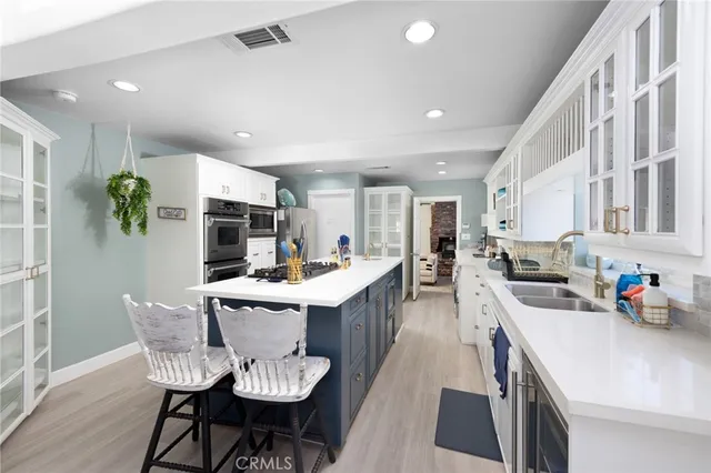a kitchen with a sink and chairs
