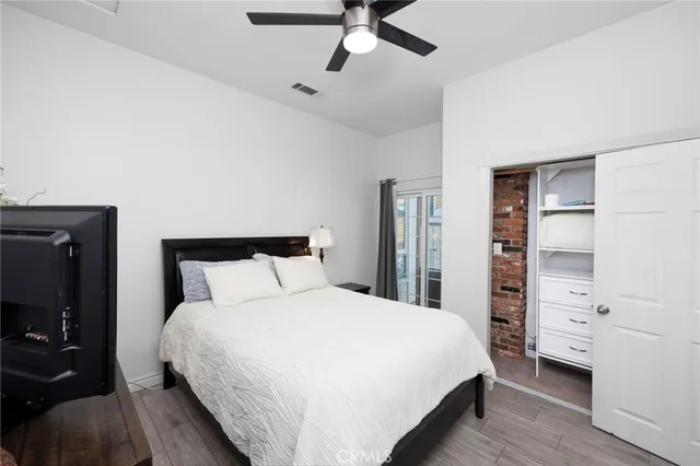 a bedroom with a bed and a flat tv screen on dresser