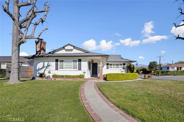 a front view of a house with a yard and trees