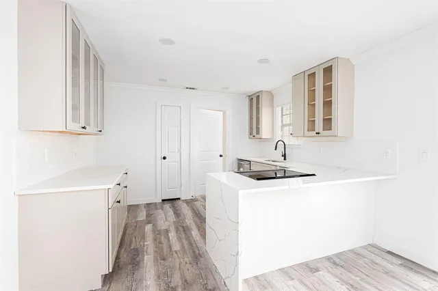 a kitchen with granite countertop a sink and a stove top oven