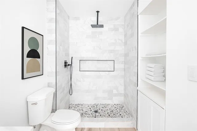 a bathroom with a shower toilet and sink