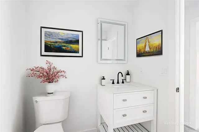 a bathroom with a toilet a sink and mirror