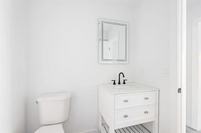 a bathroom with a toilet a sink and mirror