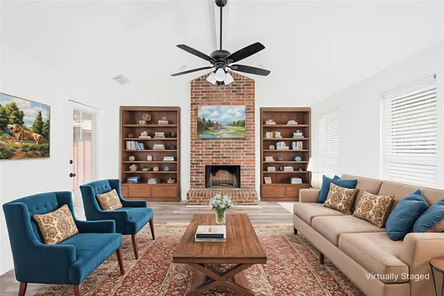a living room with furniture a fireplace and a window