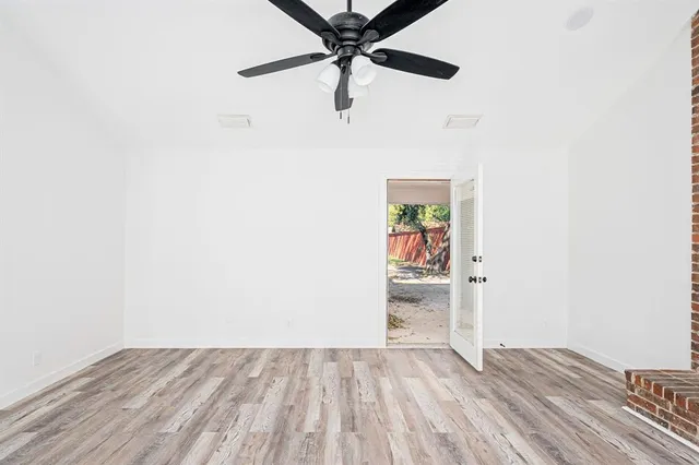 a view of a livingroom with wooden floor and a ceiling fan
