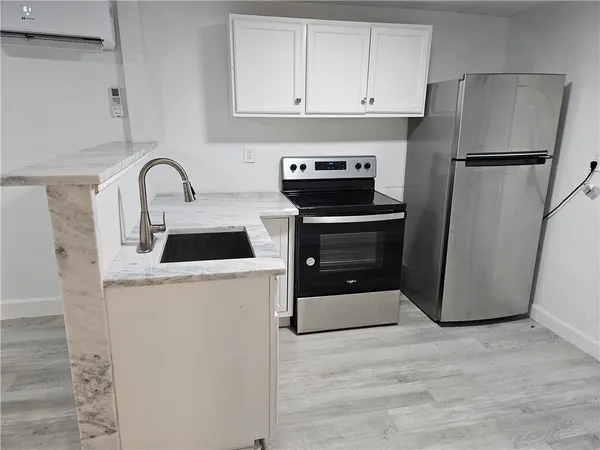 a kitchen with a refrigerator sink and cabinets