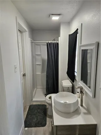 a bathroom with a sink a toilet and a mirror