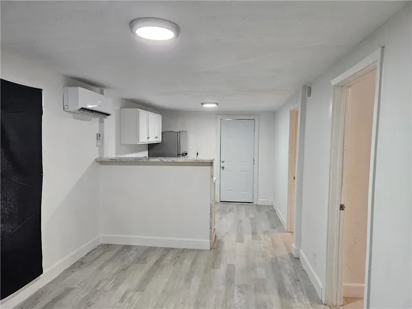 a view of a kitchen with wooden floor and electronic appliances