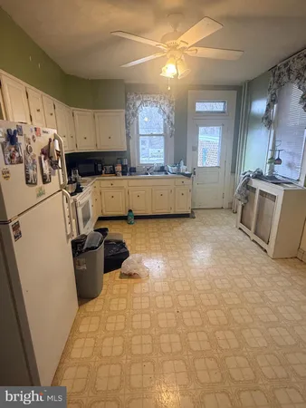 a view of a kitchen with fridge and wooden floor