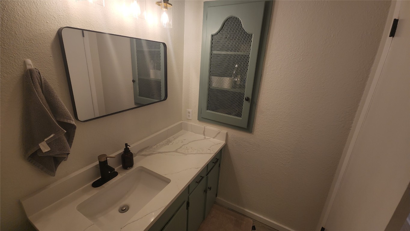 1005 West Martin Luther King Jr Boulevard Austin, TX 78701 - Photo 10 of 31 Bathroom featuring a textured wall and vanity