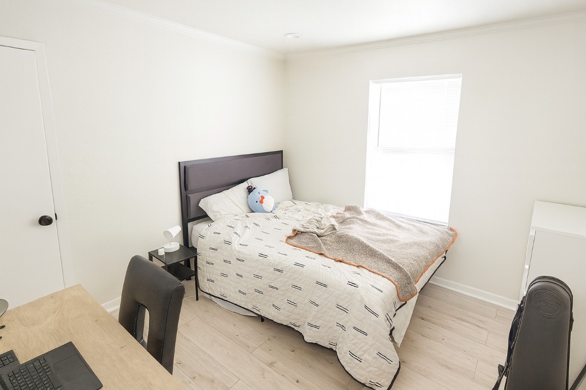1005 West Martin Luther King Jr Boulevard Austin, TX 78701 - Photo 12 of 31 Bedroom featuring wood finished floors and ornamental molding