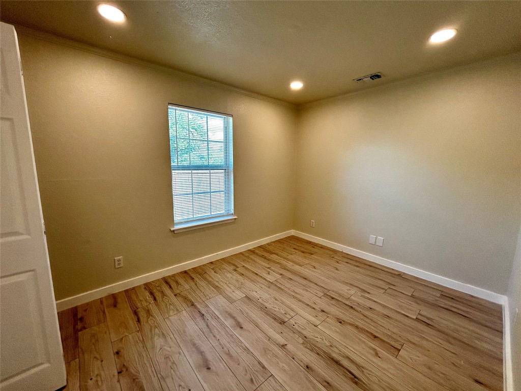 1005 West Martin Luther King Jr Boulevard Austin, TX 78701 - Photo 18 of 31 Spare room featuring light wood finished floors, recessed lighting, and crown molding