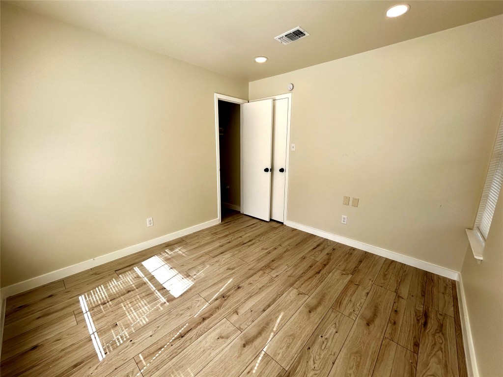 1005 West Martin Luther King Jr Boulevard Austin, TX 78701 - Photo 29 of 31 Unfurnished bedroom featuring light wood-style flooring and recessed lighting