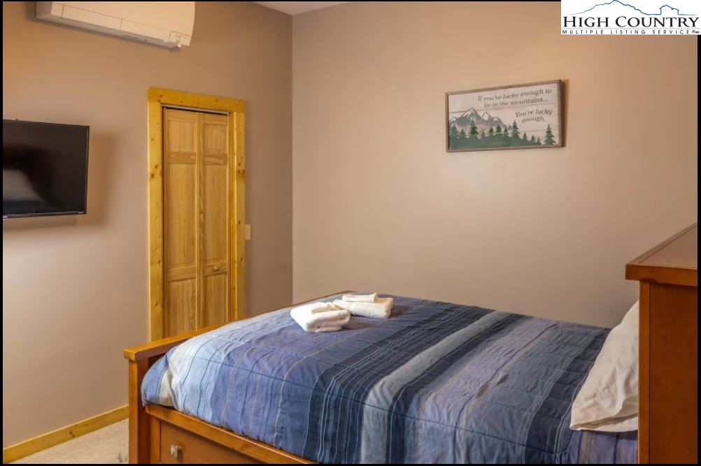 124 Aster Trail Beech Mountain, NC 28604 - Photo 17 of 26 a bedroom with a bed and a flat screen tv