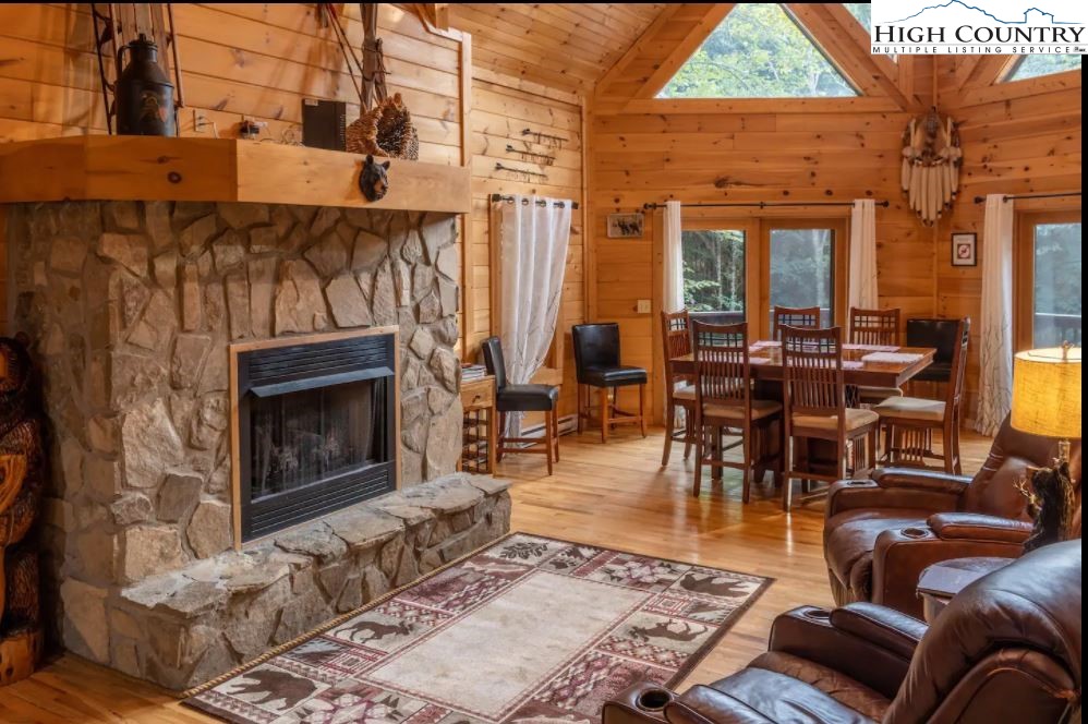 124 Aster Trail Beech Mountain, NC 28604 - Photo 3 of 26 an outdoor living area with furniture a rug and a fireplace