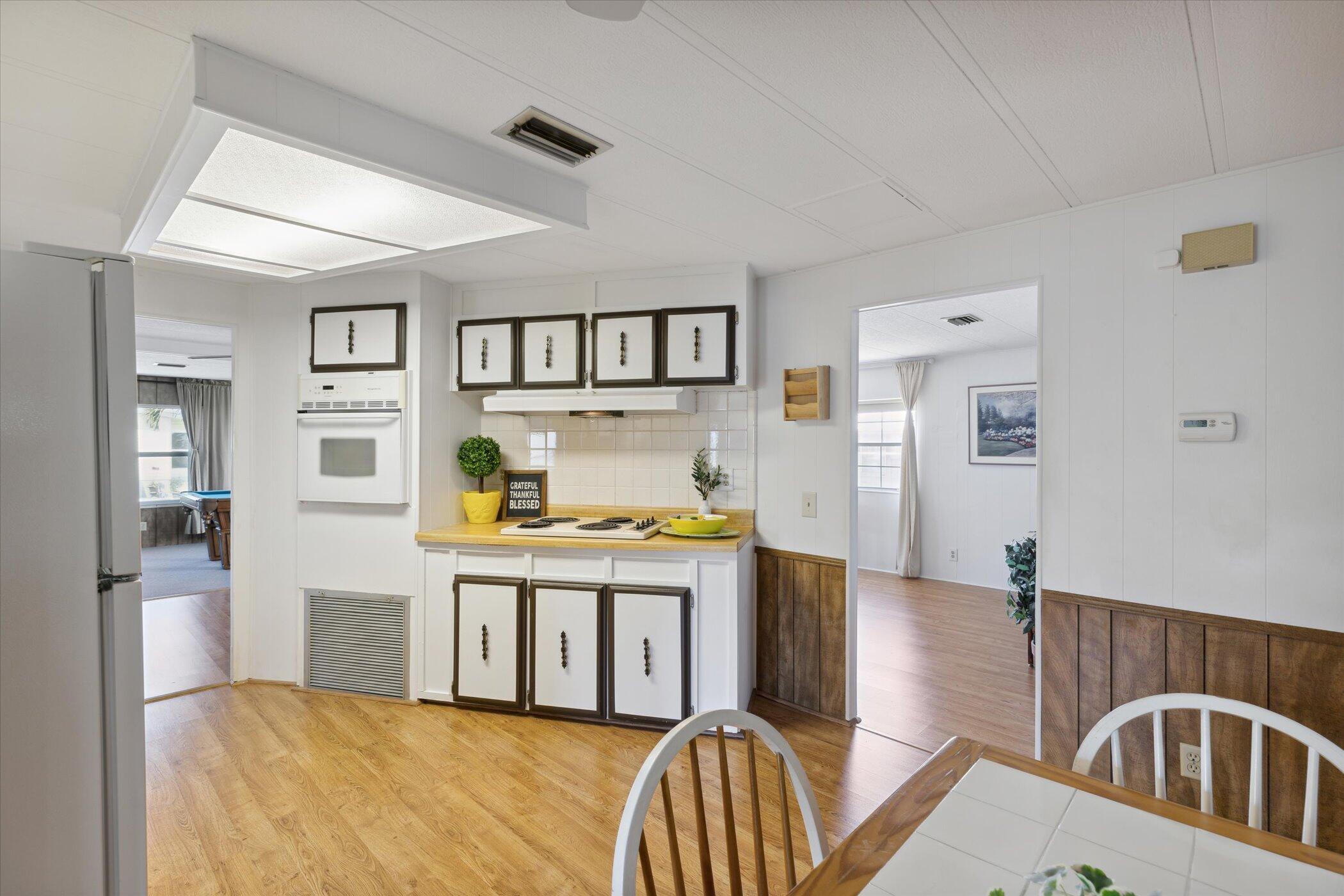 554 Ruth Circle Melbourne, FL 32904 - Photo 18 of 36 a living room with a couch and a dining table with wooden floor