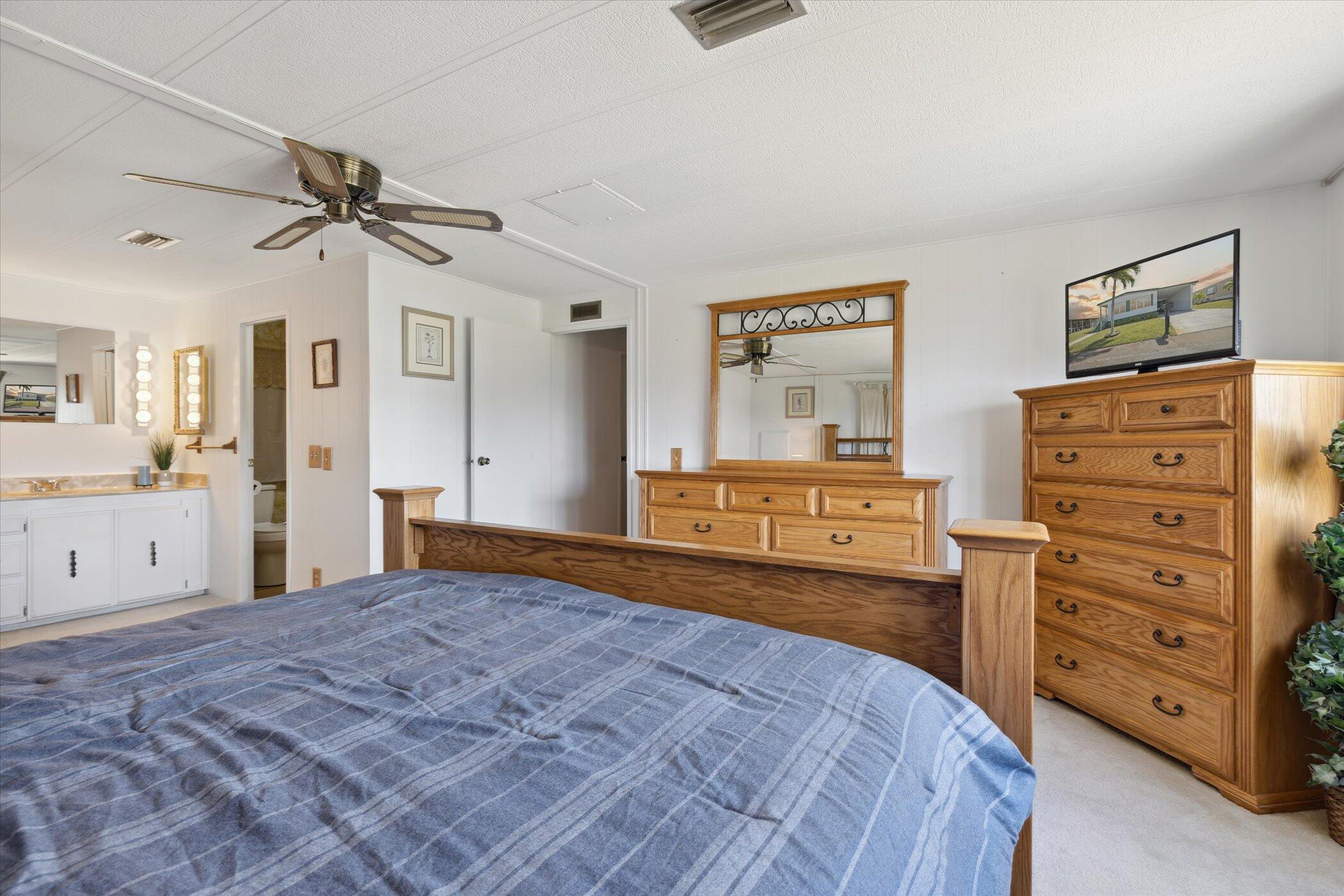 554 Ruth Circle Melbourne, FL 32904 - Photo 21 of 36 a bedroom with a dresser and a chandelier