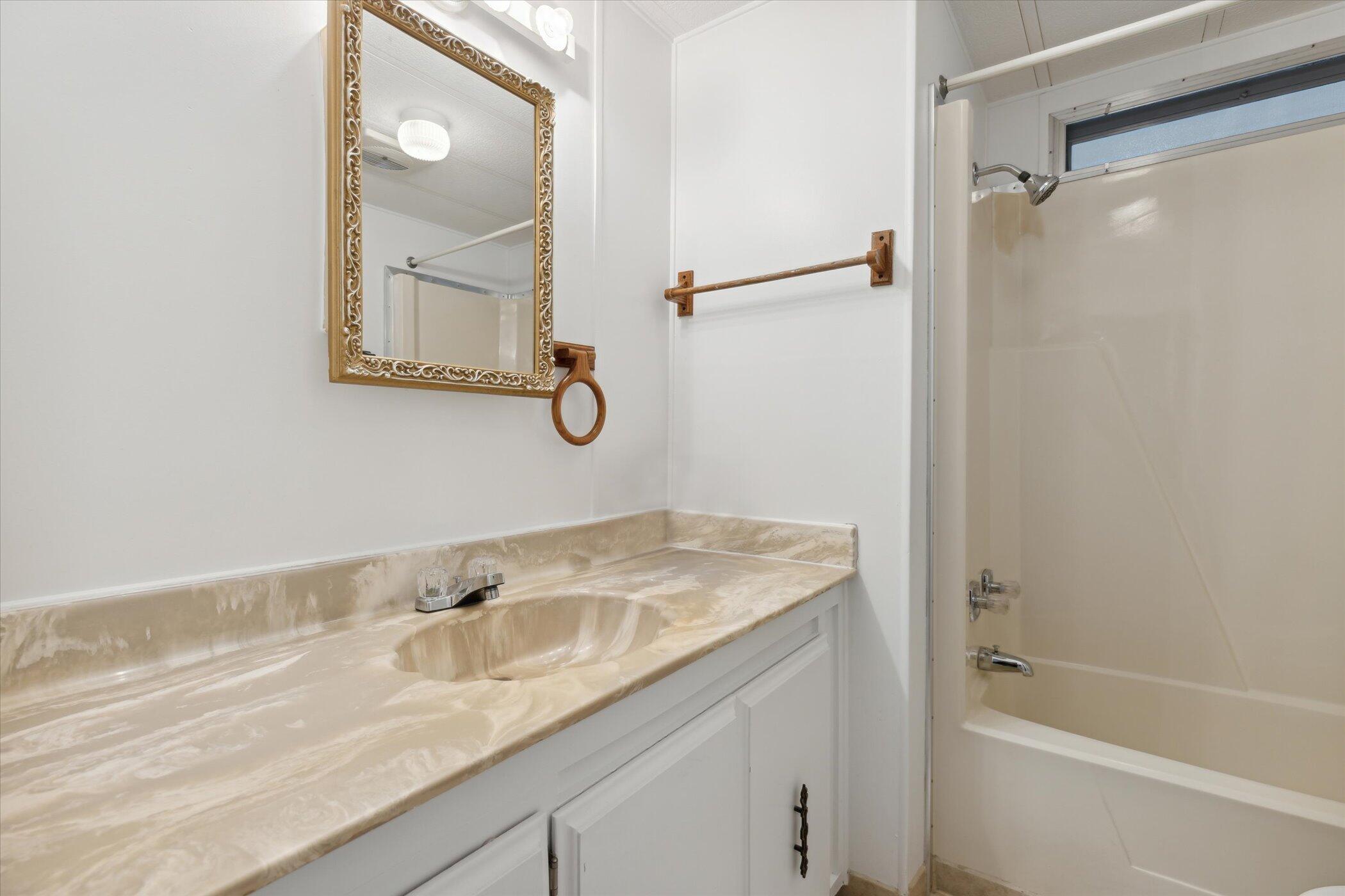 554 Ruth Circle Melbourne, FL 32904 - Photo 27 of 36 a bathroom with a granite countertop sink mirror toilet and bathtub