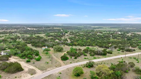an aerial view of residential houses with outdoor space and trees