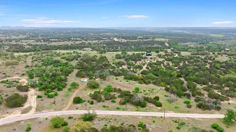 an aerial view of residential houses with outdoor space and trees