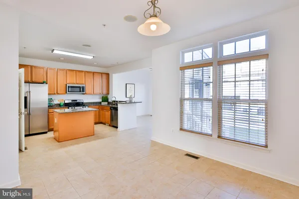 a kitchen with stainless steel appliances granite countertop a sink a stove and a refrigerator
