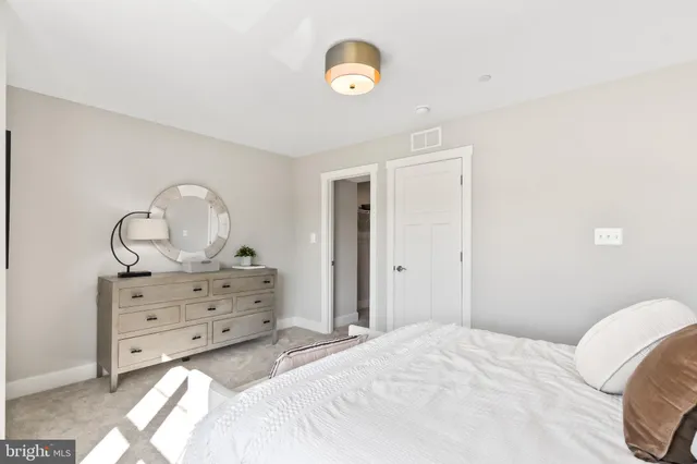 a front view of a building with a garden and plants