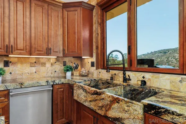 a kitchen with stainless steel appliances granite countertop a sink stove and cabinets